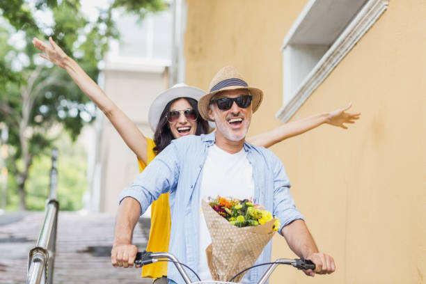 веселая пара езда на велосипеде в городе - couple loving urban scene selective focus стоковые фото и изображения