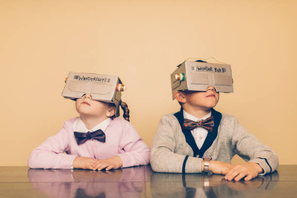 Two Young Nerds with Virtual Reality Headsets Two young nerds have made homemade versions of a virtual reality headset. With the use of their bright imagination, they can see and do anything they imagine. They are both wearing bow ties and cardigans with blank expressions on their faces. nerd kid stock pictures, royalty-free photos & images