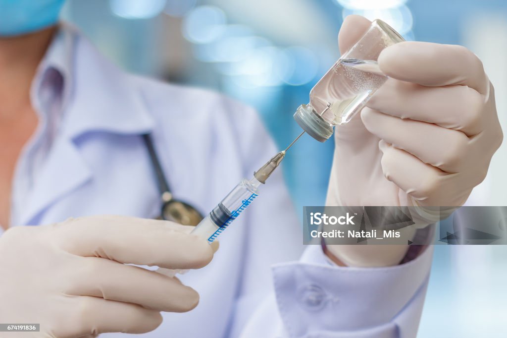 Doctor gaining in a syringe medication. Doctor gaining in a syringe medication for injection. Vaccination Stock Photo