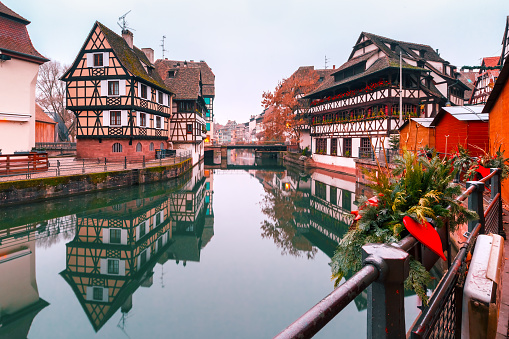 Traditional Alsatian half-timbered houses in Petite France with mirror reflections in the morning, Strasbourg, Alsace, France