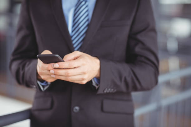 istock Midsection of businessman using mobile phone 674196410