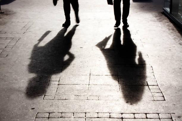 istock Blurry shadow and silhouette of two person on the sidewalk 674196512