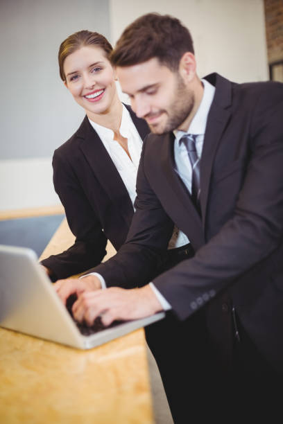 istock Business people using laptop by counter 674199792