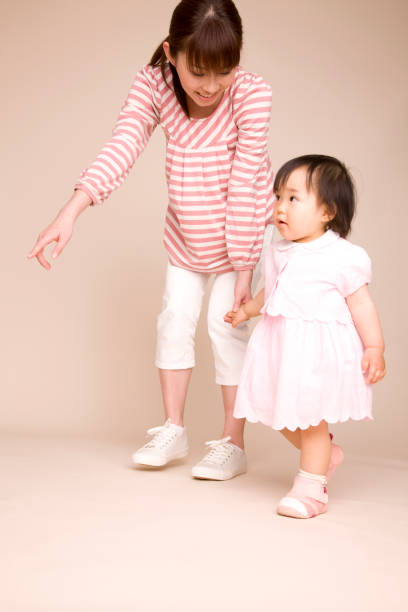 istock Baby walking and holding hands with his mother 674199930