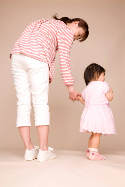 istock Baby walking and holding hands with his mother 674199938