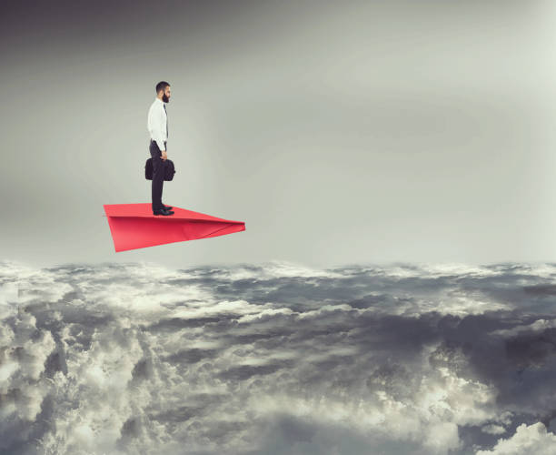 istock Businessman flying on paper airplane above clouds 674205618
