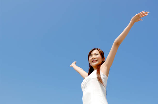 istock Woman spreading her arms under the blue sky 674205850