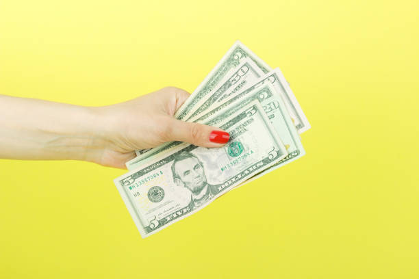 istock American dollars in the woman's hand, yellow background 674206938
