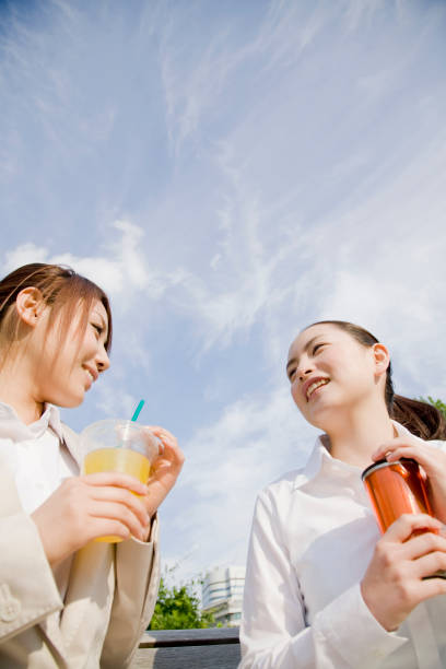 istock Two women drink on a bench in the Park 674221266