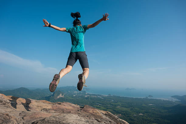 istock jumping on rocky mountain peak, freedom, risk, challenge, success concept 674221750