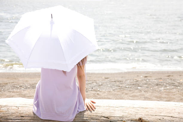 istock While piercing the parasol on the beach overlooking the sea woman from behind 674222470
