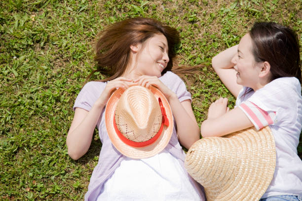 istock Two women lying on the lawn, talking 674226392