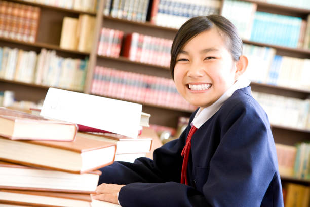 istock Female junior high school students to study in the library 674228256