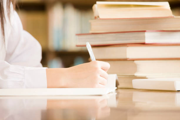istock Female junior high school students to study in the library at hand 674228476