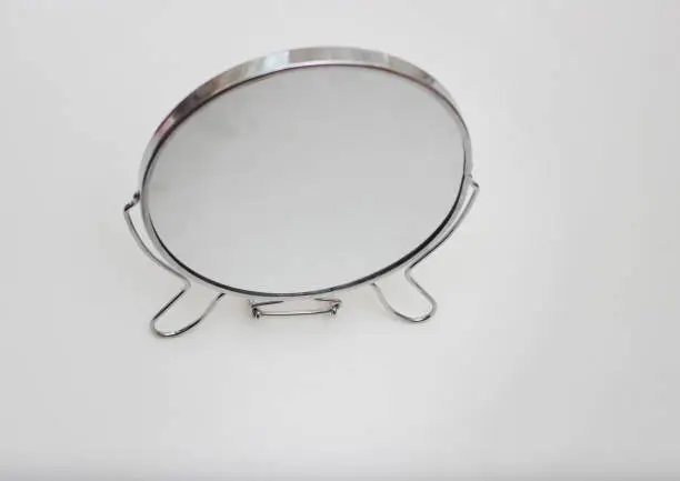 Turning mirror on white table. Mirror circle.