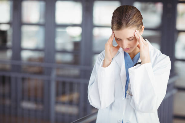 istock Tensed female doctor with head in hands 674232710
