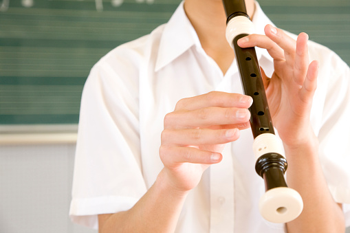 Male junior high school students blow the recorder at hand
