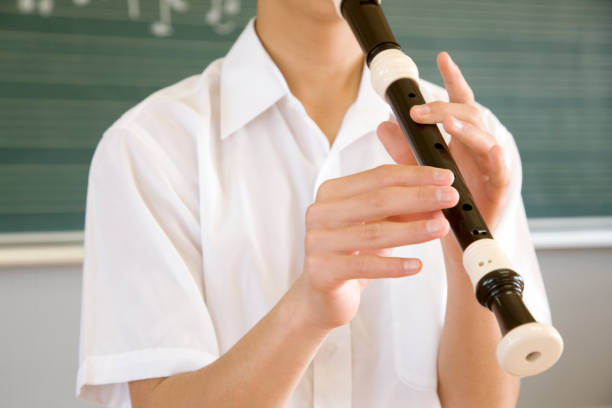 istock Male junior high school students blow the recorder at hand 674235288