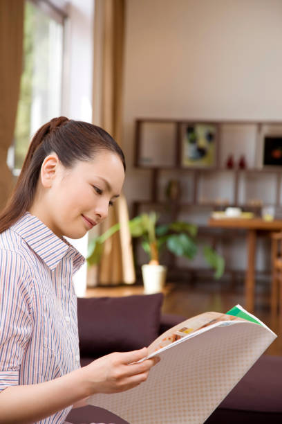 istock Women sitting on the sofa and read it from magazine 674237472