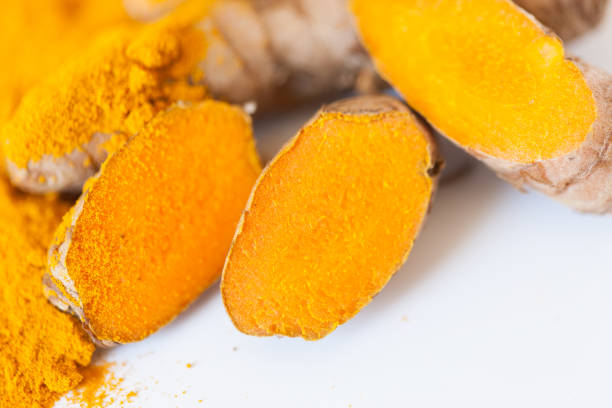 istock Turmeric roots macro with turmeric powder isolated on white background 674243532