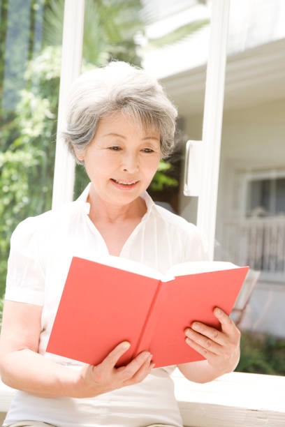 istock Senior Woman reading a book 674256550