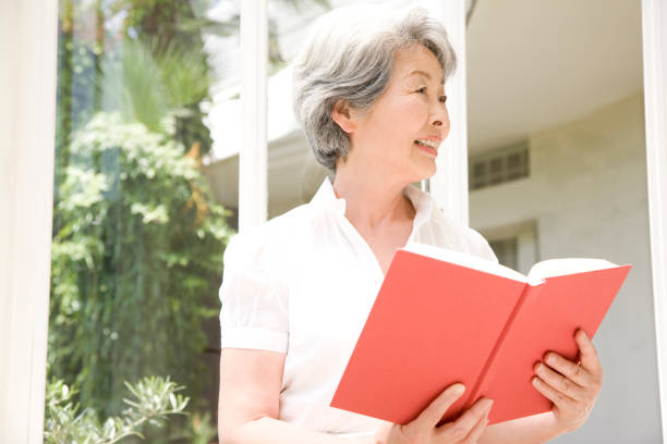 istock Senior Woman reading a book 674256872