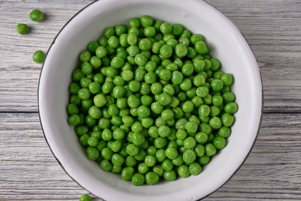 istock Fresh green pea in bowl on wooden background 674257868