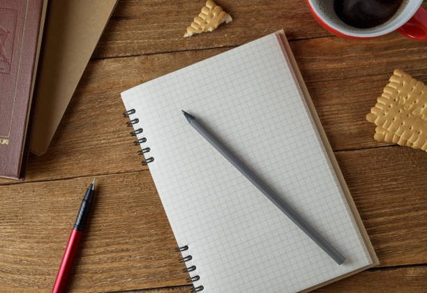 istock Blank notebook, pencil and cup of coffee on a wooden background 674257954