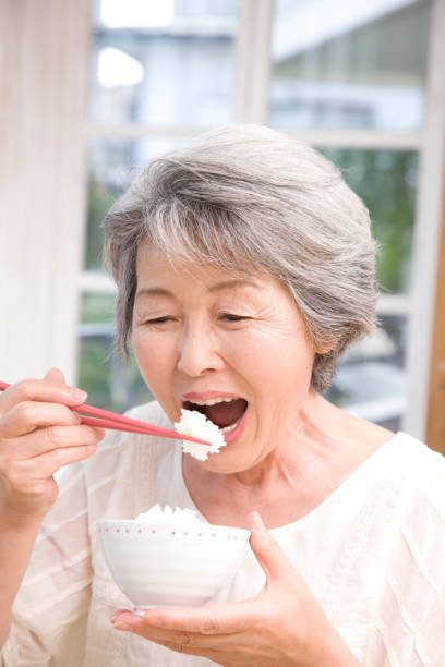istock Senior woman eating white rice 674258612