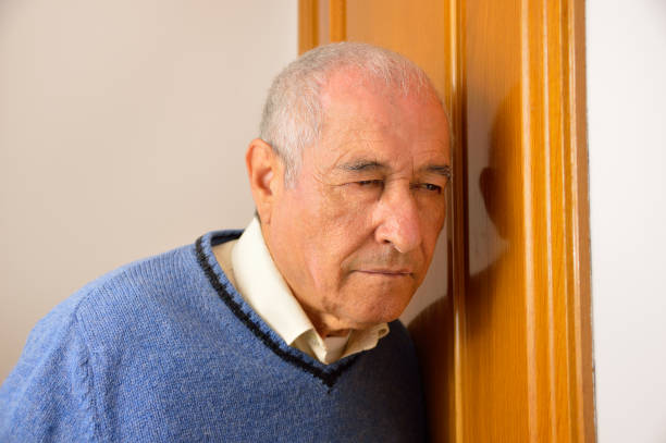 istock senior man listening behind the door 674265544