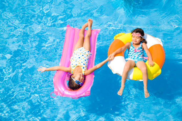 istock Two girls wearing a swimsuit in the float pool float 674280176