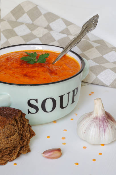 Lentil cream soup in a rustic bowl with piece of black  bread