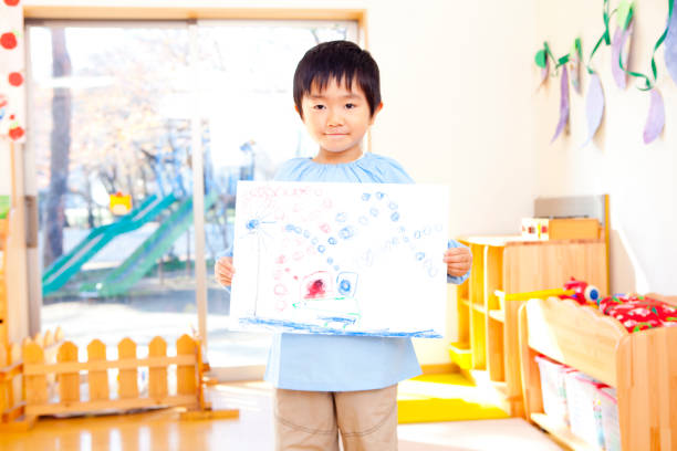 istock Kindergarten boy holding painting 674286686