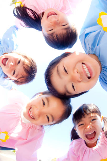 istock Kindergarten children in a circle and laugh at five 674291104
