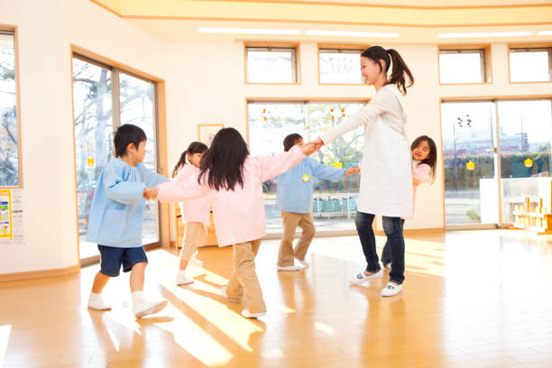 幼稚園および幼稚園教師、輪になって踊る - preschool ストックフォトと画像