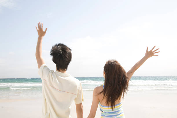 istock Couple waving towards the sea 674297462