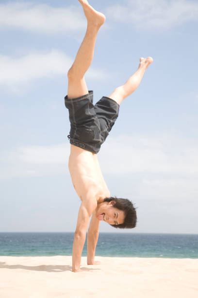 istock Men do cartwheels on the beach 674297888