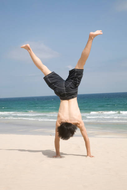 istock Men do cartwheels on the beach 674297902