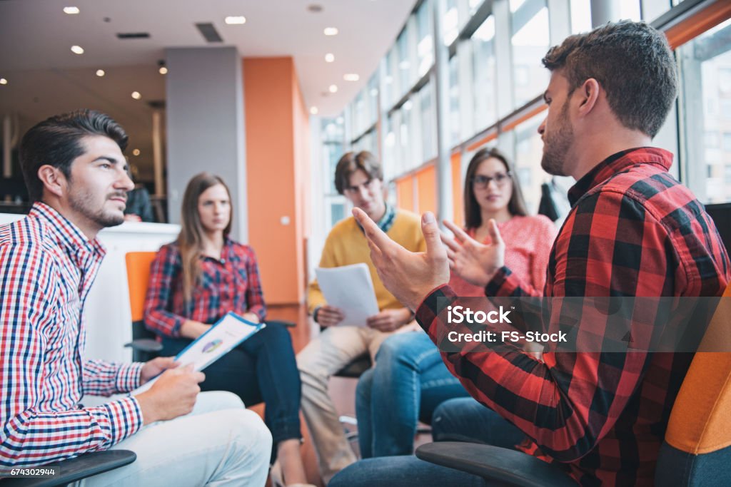 Shot of a group of young business professionals having a meeting. Shot of a group of young business professionals having a meeting. Diverse group of young designers smiling during a meeting at the office. Casual Clothing Stock Photo