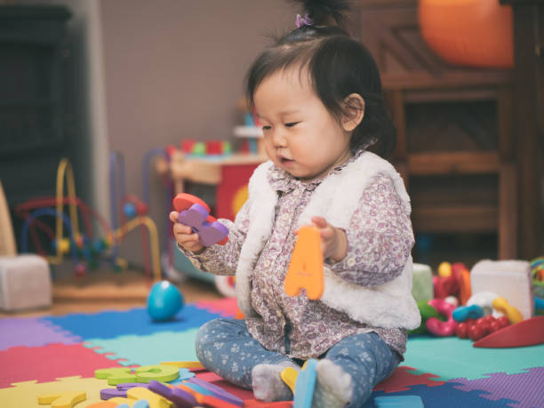 istock baby girl playing alphabet blocks 674312824