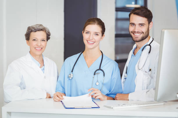istock Portrait of smiling doctor team standing at computer desk 674320536