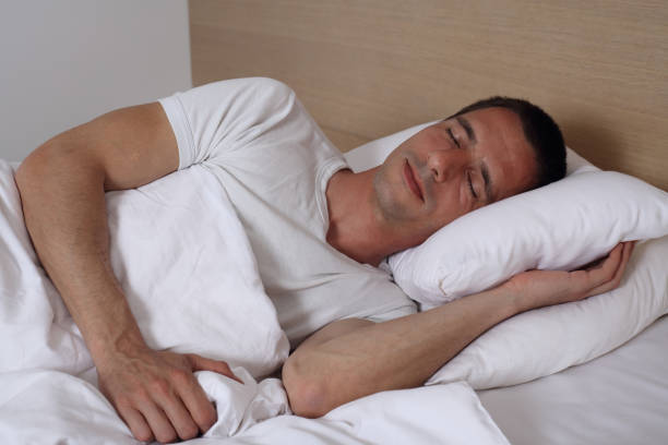 Young handsome man sleeping comfortably in bed.