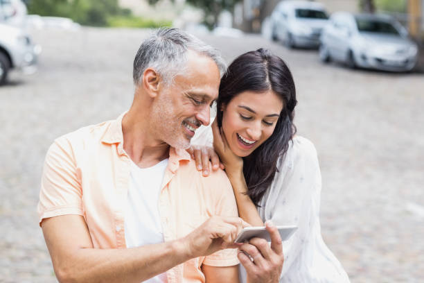 istock Couple using phone at street 674331534