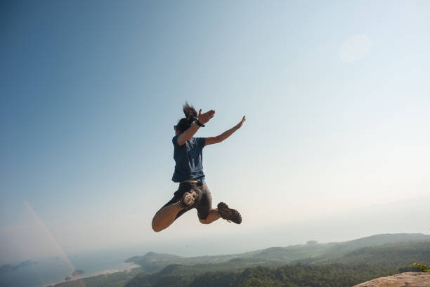 istock jumping on rocky mountain peak, freedom, risk, challenge, success concept 674331774