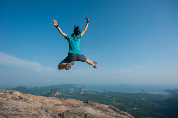 istock jumping on rocky mountain peak, freedom, risk, challenge, success concept 674333506