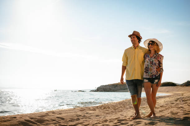 istock Romantic couple walking on the beach in summer 674339098