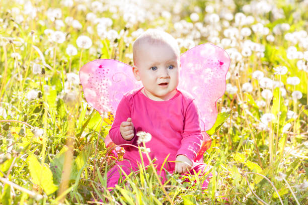 A beautiful baby girl, seven months old, sitting in a garden. Shot with a Canon 5D Mark IV.