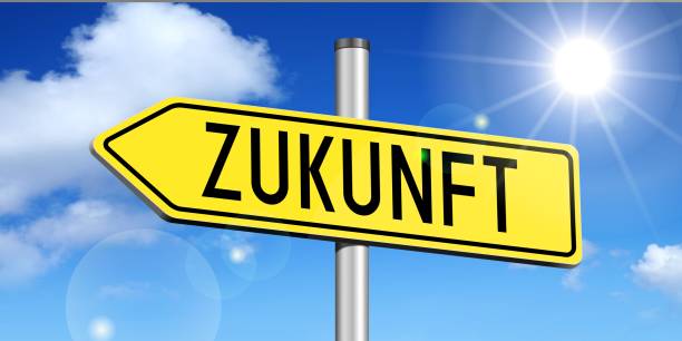 Yellow metal signpost/ traffic sign with one arrow - "Zukunft" (German)/ "Future" (English) - sky with clouds, sun.