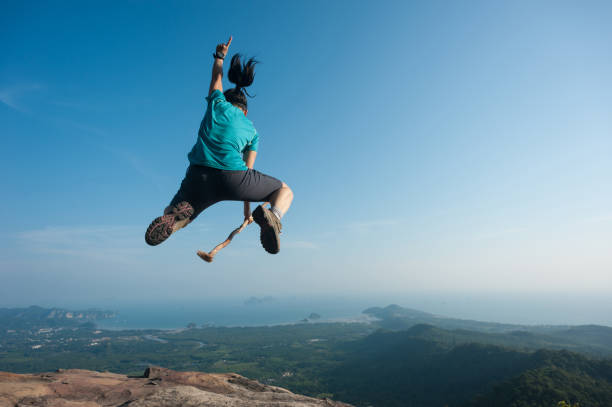 istock jumping on rocky mountain peak, freedom, risk, challenge, success concept 674352356