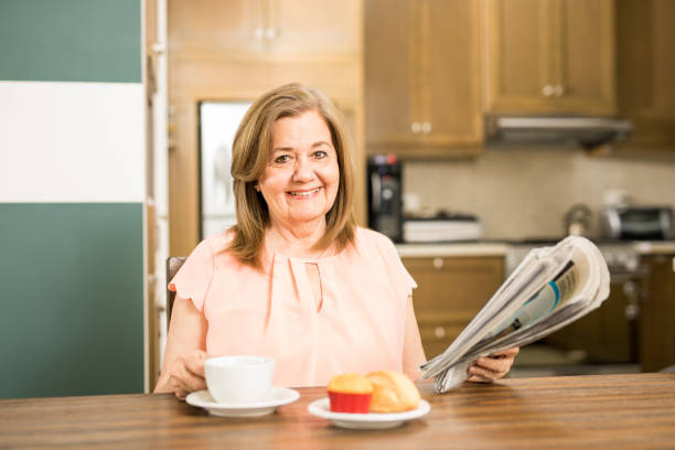 istock Aged woman reading and eating breakfast 674355192